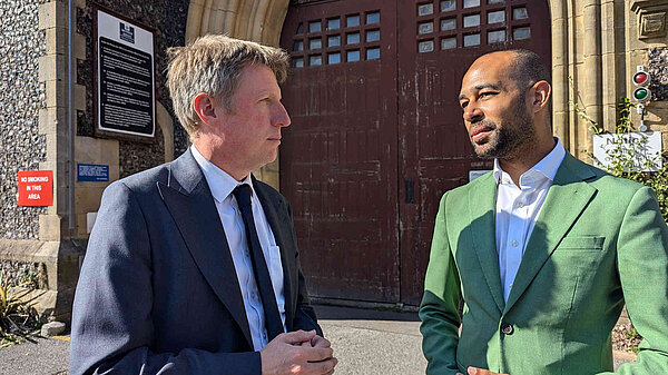 James with Josh Babarinde in front of the imposing wooden gates of Lewes prison